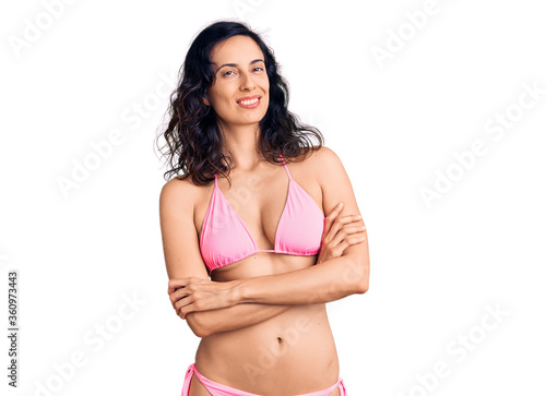 Young beautiful hispanic woman wearing bikini happy face smiling with crossed arms looking at the camera. positive person. © Krakenimages.com