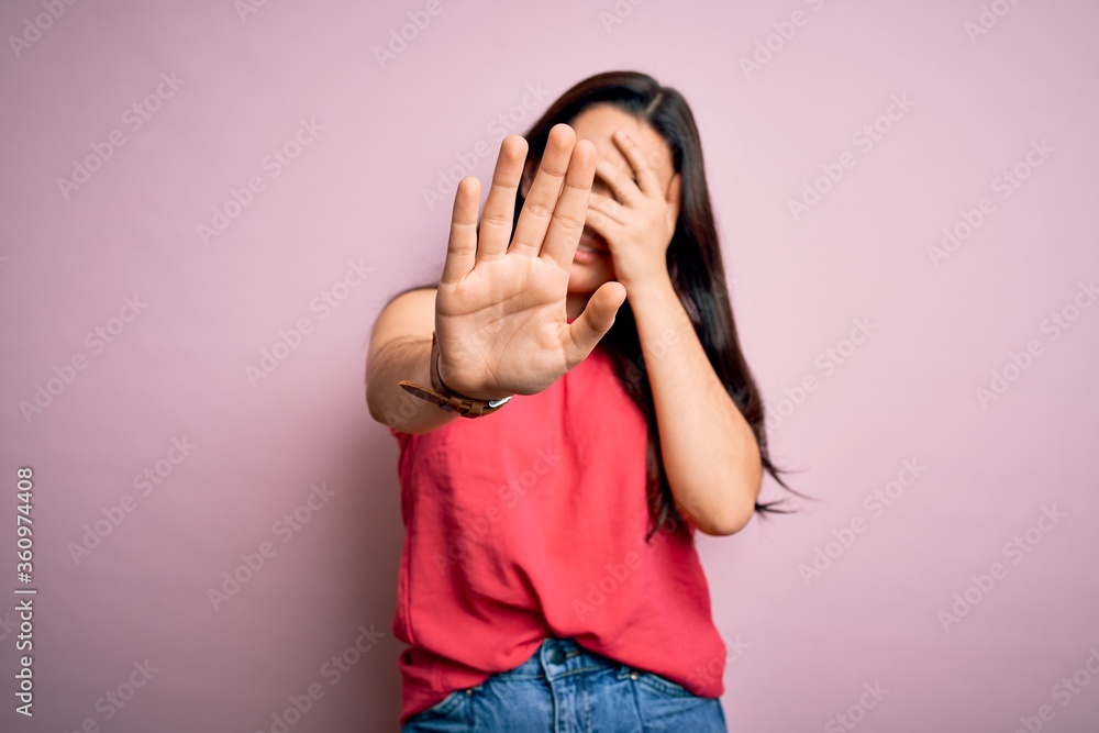 Young brunette woman wearing casual summer shirt over pink isolated background covering eyes with hands and doing stop gesture with sad and fear expression. Embarrassed and negative concept. Young brunette woman wearing casual summer shirt over pink isolated background covering eyes with hands and doing stop gesture with sad and fear expression. Embarrassed and negative concept.