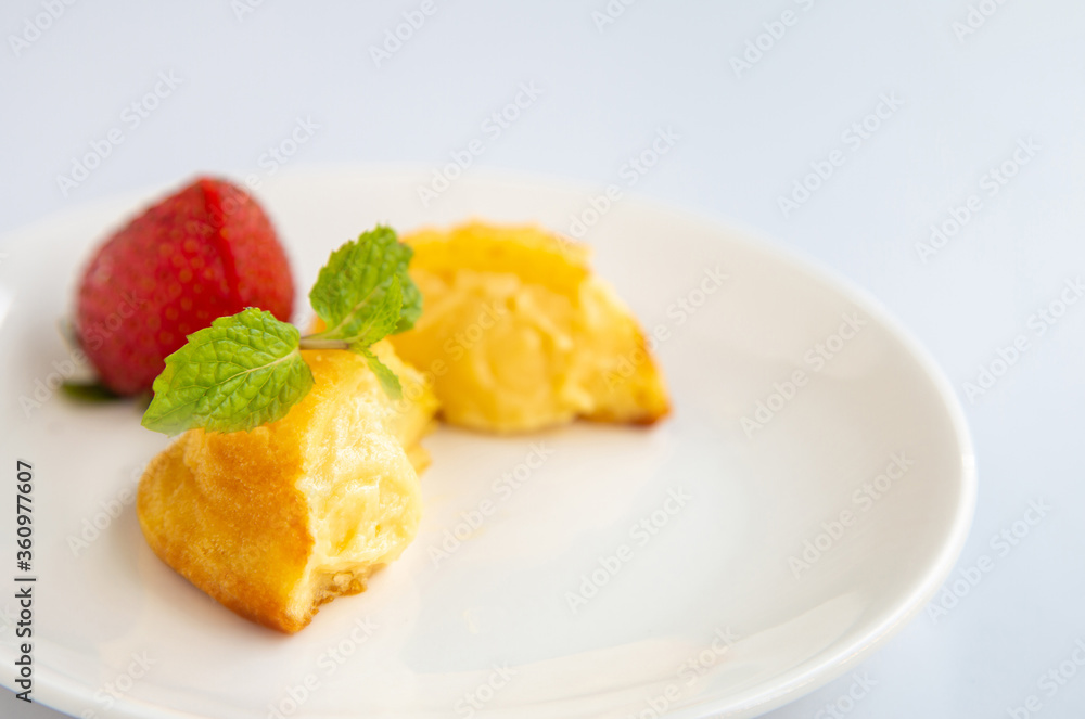 Close up a group of homemade Choux (Eclair) in a white dish on a white table Close up a group of homemade Choux (Eclair) in a white dish on a white table