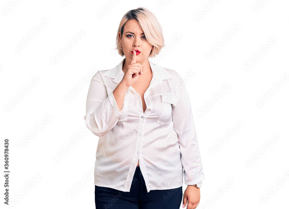 Young blonde plus size woman wearing casual shirt asking to be quiet with finger on lips. silence and secret concept. Young blonde plus size woman wearing casual shirt asking to be quiet with finger on lips. silence and secret concept.