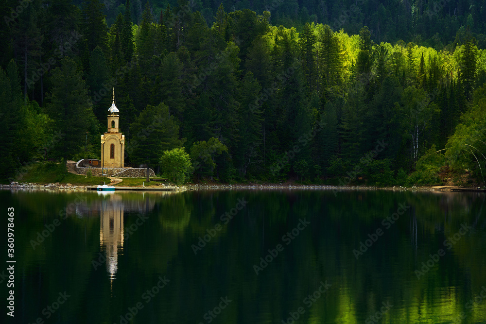 chapel built in a wooded area on the lake, the concept of the unity of nature and religion. holy place and faith