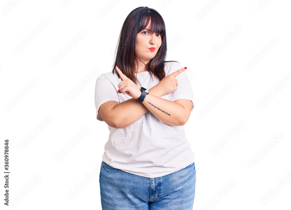Young plus size woman wearing casual clothes pointing to both sides with fingers, different direction disagree Young plus size woman wearing casual clothes pointing to both sides with fingers, different direction disagree