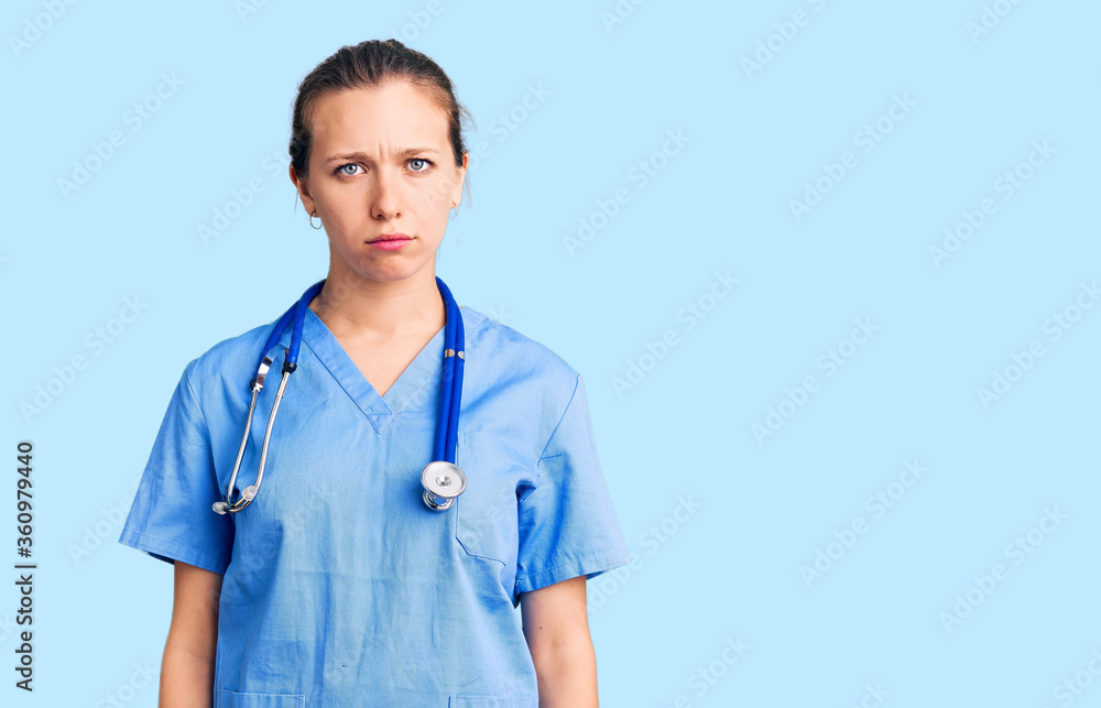 Young beautiful blonde woman wearing doctor uniform and stethoscope skeptic and nervous, frowning upset because of problem. negative person. Young beautiful blonde woman wearing doctor uniform and stethoscope skeptic and nervous, frowning upset because of problem. negative person.