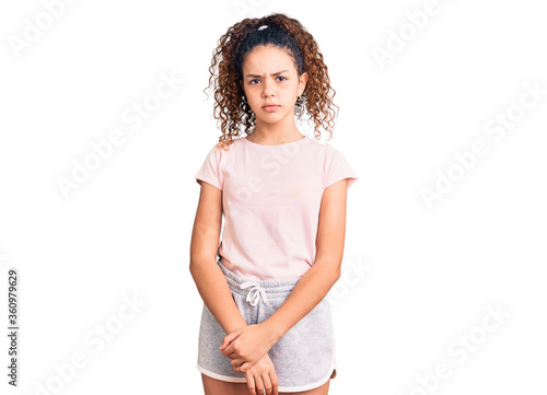 Obraz na plátne Beautiful kid girl with curly hair wearing casual clothes skeptic and nervous, frowning upset because of problem