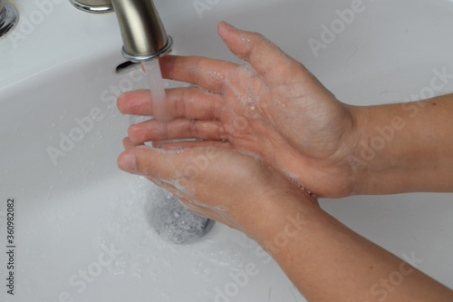 Close up of female washing hands in a public bathroom. Increased hygiene during Covid crises. Wash your hands often