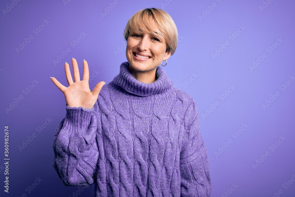 Young blonde woman with short hair wearing winter turtleneck sweater over purple background showing and pointing up with fingers number five while smiling confident and happy. Young blonde woman with short hair wearing winter turtleneck sweater over purple background showing and pointing up with fingers number five while smiling confident and happy.