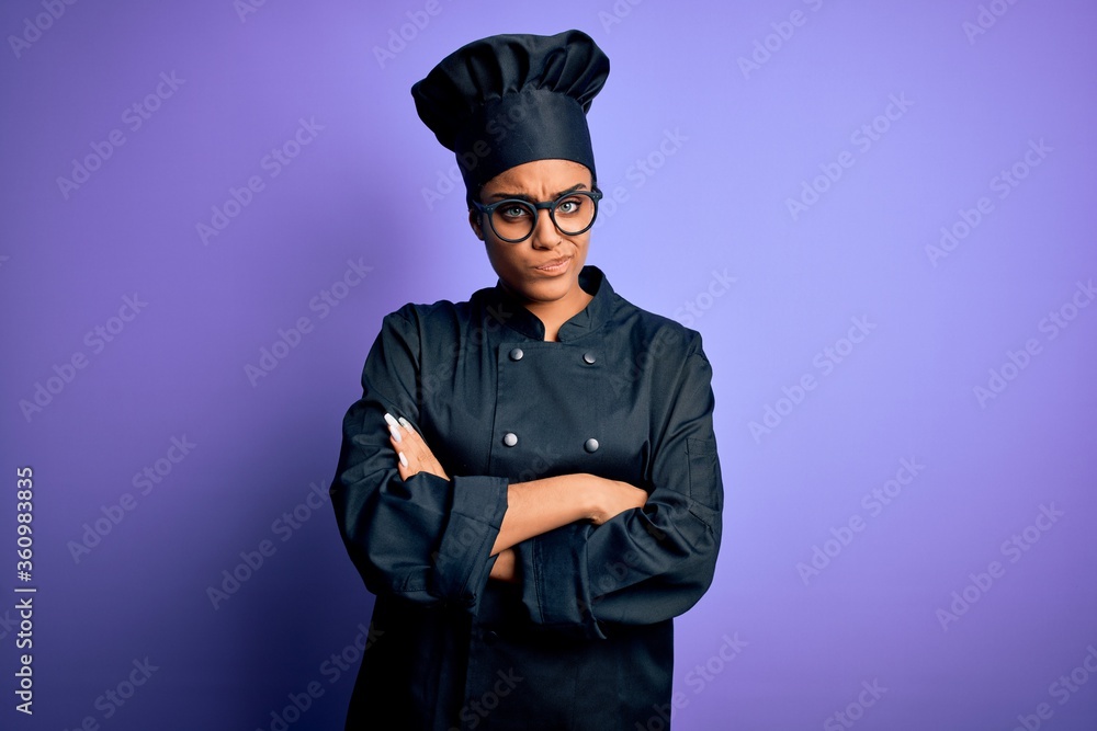 Young african american chef girl wearing cooker uniform and hat over purple background skeptic and nervous, disapproving expression on face with crossed arms. Negative person. Young african american chef girl wearing cooker uniform and hat over purple background skeptic and nervous, disapproving expression on face with crossed arms. Negative person.