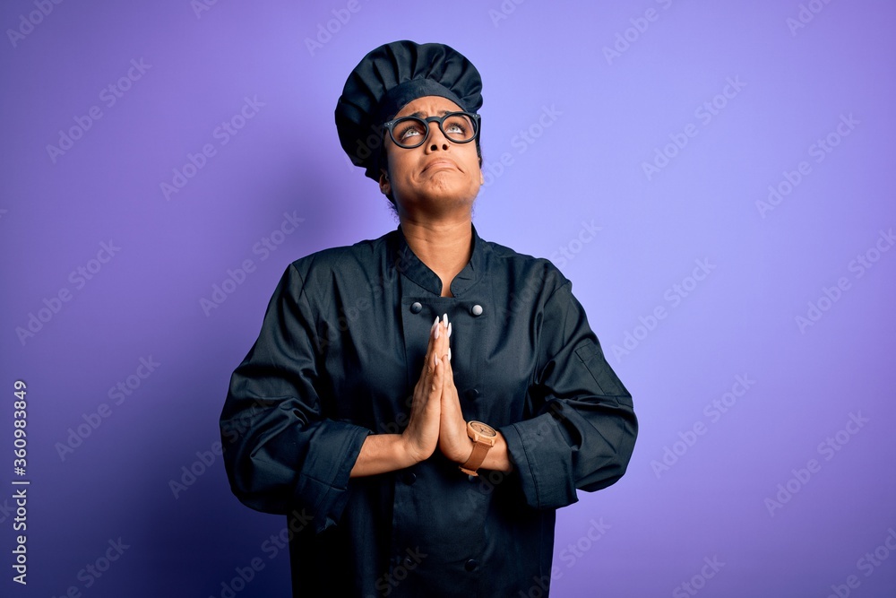 Young african american chef girl wearing cooker uniform and hat over purple background begging and praying with hands together with hope expression on face very emotional and worried. Begging. Young african american chef girl wearing cooker uniform and hat over purple background begging and praying with hands together with hope expression on face very emotional and worried. Begging.