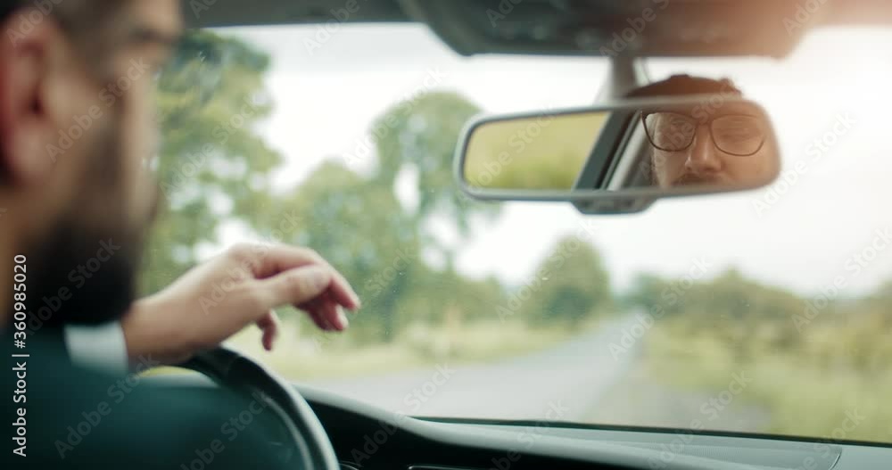 Reflection in back mirror of mature bearded man in black suit and tie. Successful businessman in eyeglasses doing all adjustments before driving car. Reflection in back mirror of mature bearded man in black suit and tie. Successful businessman in eyeglasses doing all adjustments before driving car.