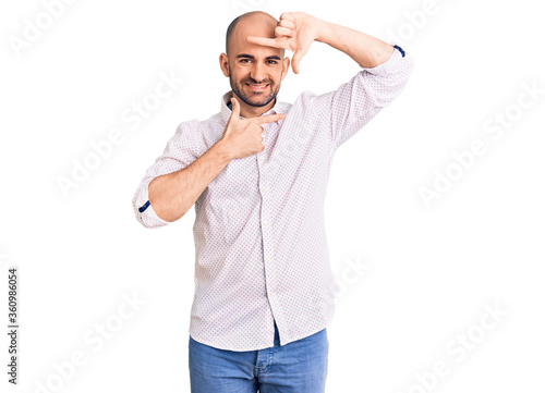 Young handsome man wearing elegant shirt smiling making frame with hands and fingers with happy face. creativity and photography concept.