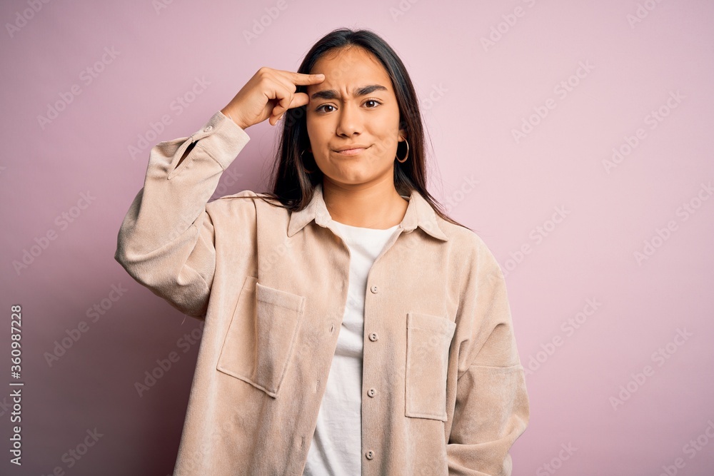 Young beautiful asian woman wearing casual shirt standing over pink background pointing unhappy to pimple on forehead, ugly infection of blackhead. Acne and skin problem Young beautiful asian woman wearing casual shirt standing over pink background pointing unhappy to pimple on forehead, ugly infection of blackhead. Acne and skin problem