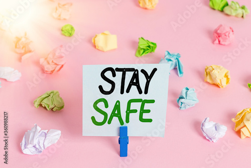 Word writing text Stay Safe. Business photo showcasing secure from threat of danger, harm or place to keep articles Colored crumpled papers empty reminder pink floor background clothespin photo