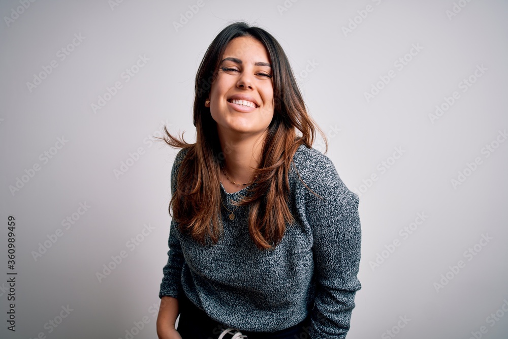 Young beautiful brunette woman smiling happy and confident. Standing with smile on face wearing casual sweater over isolated white background Young beautiful brunette woman smiling happy and confident. Standing with smile on face wearing casual sweater over isolated white background