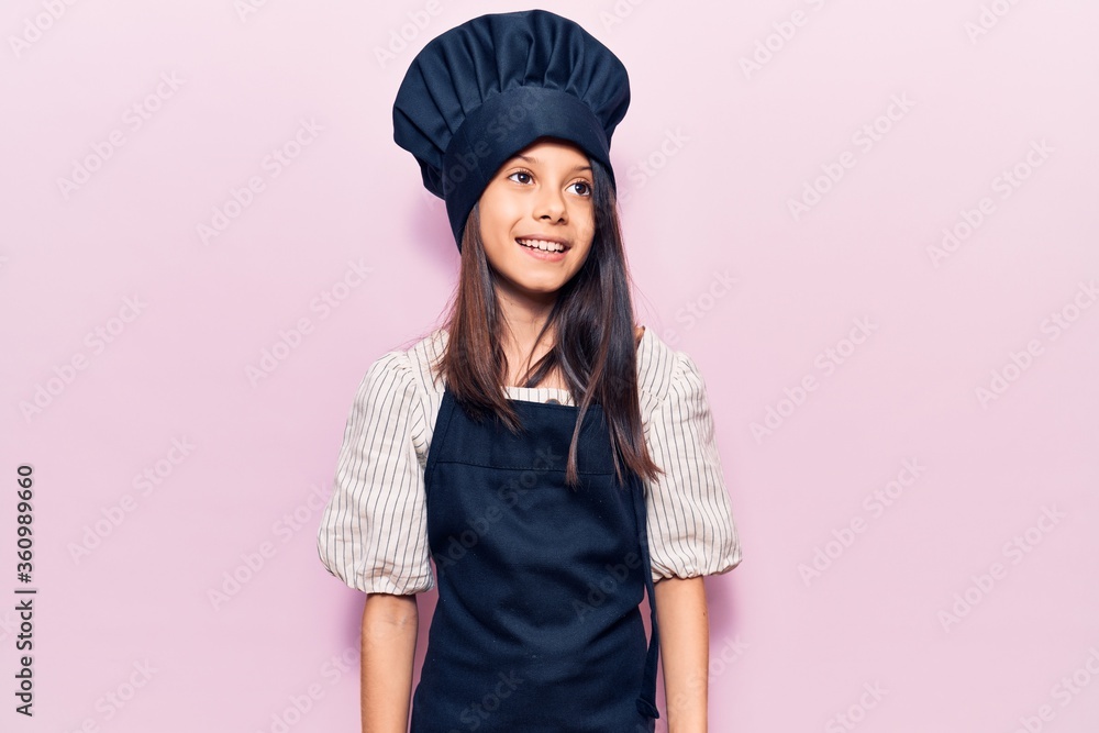 Beautiful child girl wearing cooker uniform looking to side, relax profile pose with natural face and confident smile. Beautiful child girl wearing cooker uniform looking to side, relax profile pose with natural face and confident smile.
