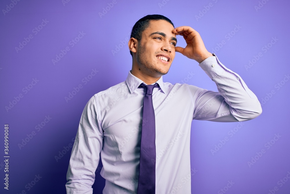 Young brazilian businessman wearing elegant tie standing over isolated purple background smiling confident touching hair with hand up gesture, posing attractive and fashionable Young brazilian businessman wearing elegant tie standing over isolated purple background smiling confident touching hair with hand up gesture, posing attractive and fashionable
