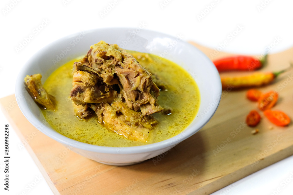 Opor ayam, chicken cooked in coconut milk traditional food from Indonesia isolated on white background.