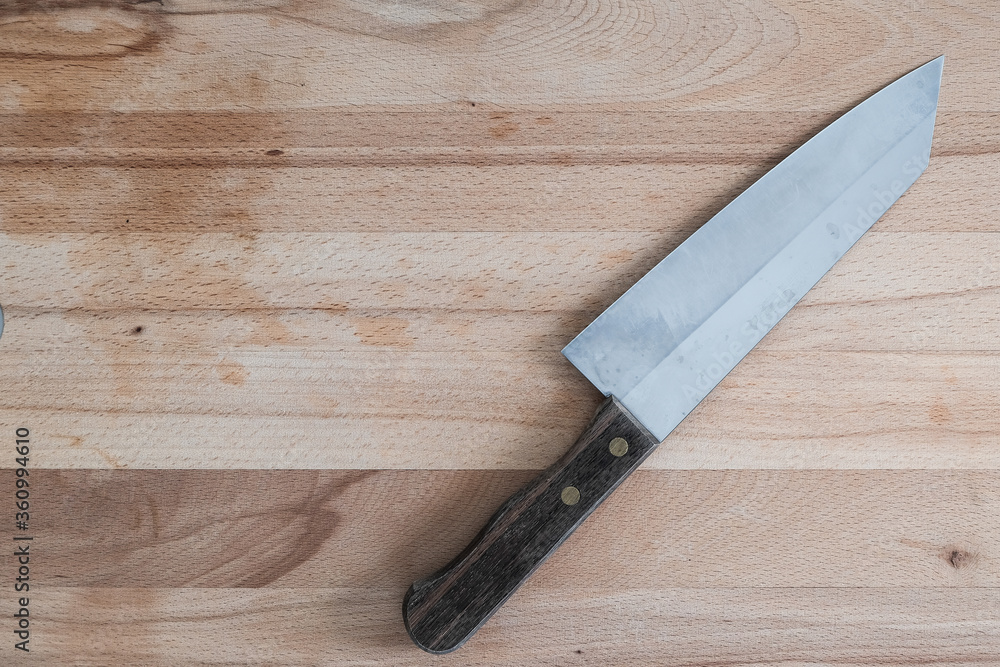 Knife on brown wooden cutting board on kitchen background Knife on brown wooden cutting board on kitchen background
