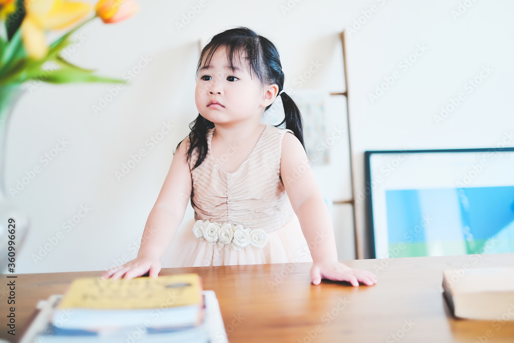 Cute asian girl learning by reading and studying books and playing at home in the living room sitting, home schooling education for children, feeling happy cheerful, and enjoying staying at home Cute asian girl learning by reading and studying books and playing at home in the living room sitting, home schooling education for children, feeling happy cheerful, and enjoying staying at home