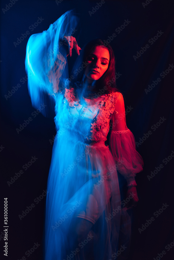 blurry girl in a dress is dancing on a dark background