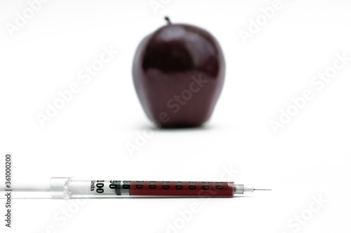 Syringe injection into a red apple. Genetic modified foods