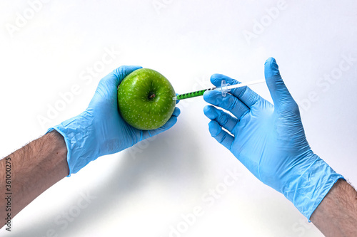 Syringe injection into a apple with sorbic acid waiting for long-term storage of fruit. Genetic modified foods. isolated on white background