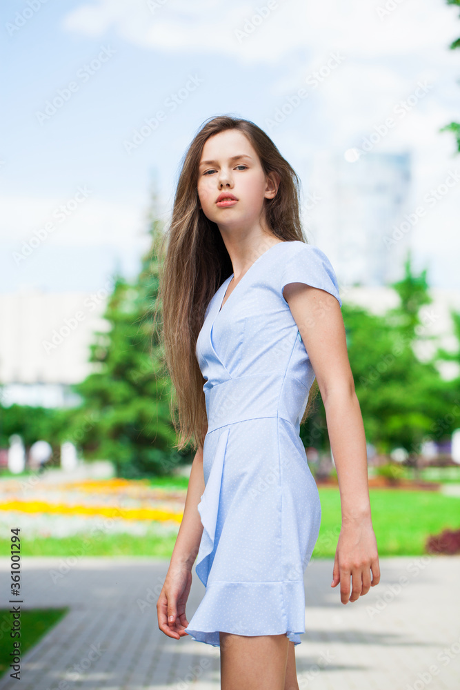 Portrait of a young beautiful teenager girl in blue dress