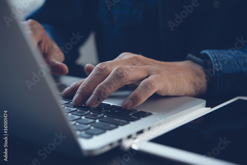 Close up of man hand typing on laptop computer keyboard 