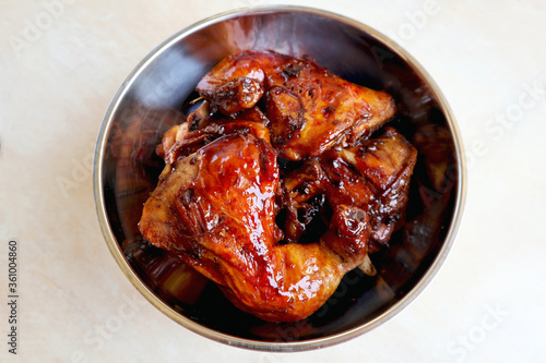 Homemade Kalasan Grilled Chicken (Ayam Bakar) with aluminium bowl from up above high angle view, is one of an Indonesian food from Kalasan, Yogyakarta with sweet and savory tastes from black soy sauce