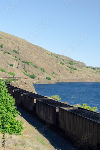 Coal train running along Columbia River in Washington State Columbia River Gorge.