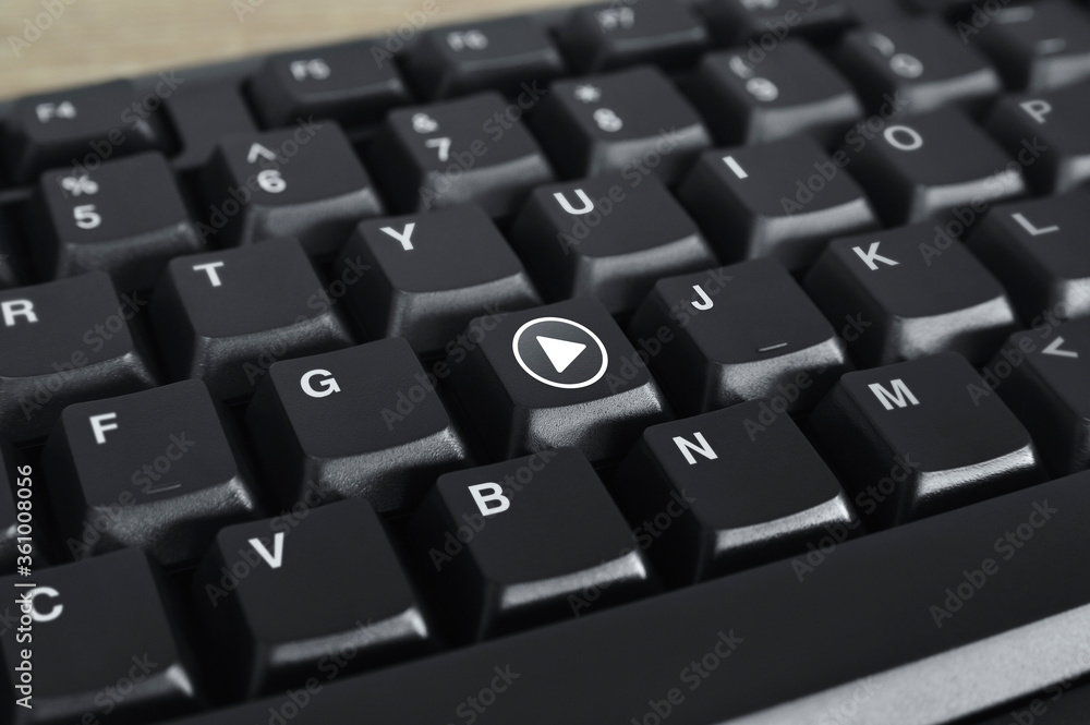 Play button flat icon on black computer keyboard button, Business music online concept Play button flat icon on black computer keyboard button, Business music online concept