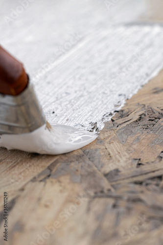 Wallpaper Mural brush paints area flat surface with white paint against wood background Torontodigital.ca