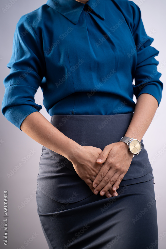 Closeup  shot of woman having painful holding hands pressing her crotch isolated on background