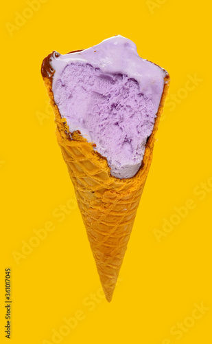 angle view sweet potato flavor ice cream cone with some bites on yellow background