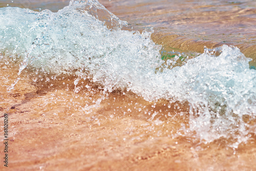 Sea wave on the sand beach, soft focus. Summer background