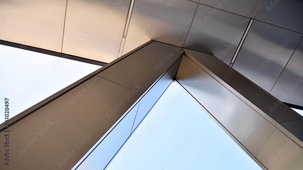 Combination of metal and glass wall material. Steel facade on columns. Abstract modern architecture. High-tech minimalist office building. Contemporary business architecture abstract fragment. Combination of metal and glass wall material. Steel facade on columns. Abstract modern architecture. High-tech minimalist office building. Contemporary business architecture abstract fragment.