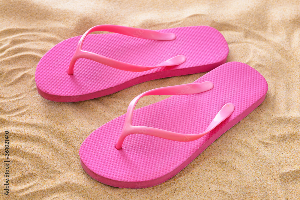 Stylish flip-flops on beach sand Stylish flip-flops on beach sand