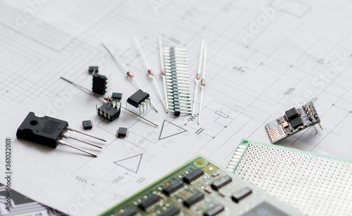 Electronic parts on the background of the schematic diagram. Diodes, microchips, transistors, integrated circuits, capacitors.Design of electronic circuit and electronic Board.Connection diagram