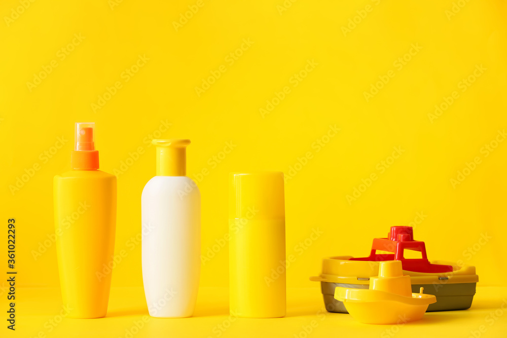Sunscreen cream with beach sand toys on color background Sunscreen cream with beach sand toys on color background