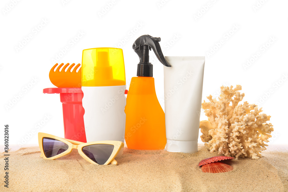Sunscreen cream with beach sand toys and sunglasses on white background Sunscreen cream with beach sand toys and sunglasses on white background