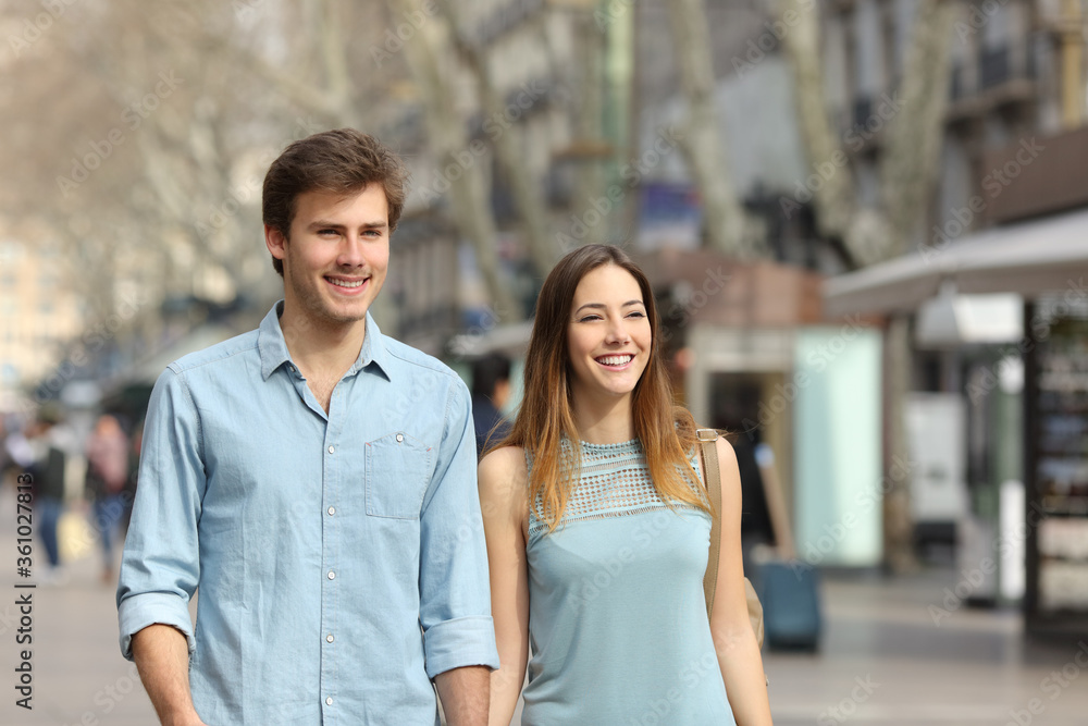 Couple holding hands walking in the street