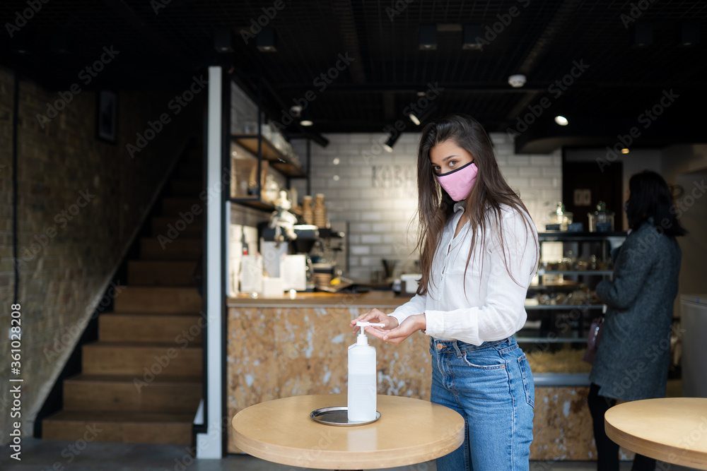Woman using sanitizer gel cleans hands of coronavirus virus at cafe. Woman using sanitizer gel cleans hands of coronavirus virus at cafe.