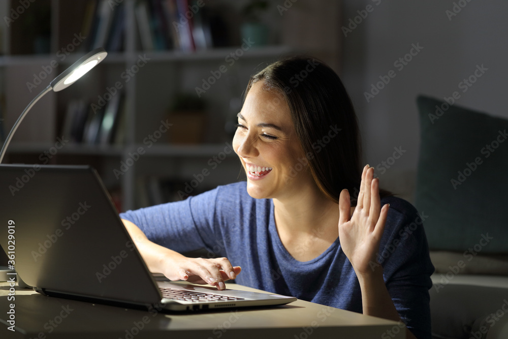 Happy woman on videocall with laptop at night at home Happy woman on videocall with laptop at night at home