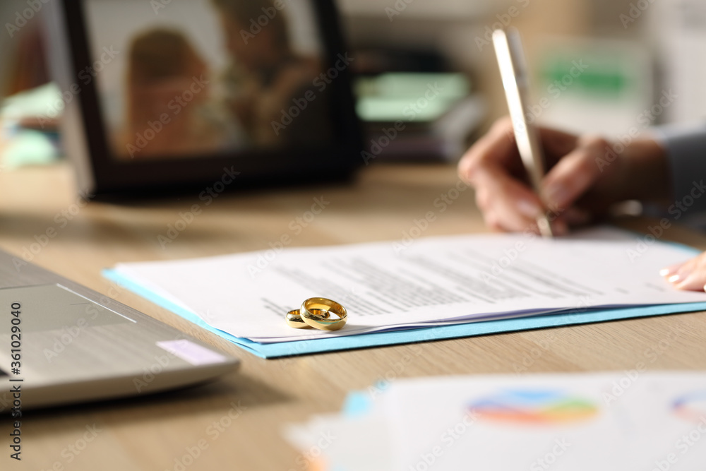 Entrepreneur hand signing divorce papers at home Entrepreneur hand signing divorce papers at home