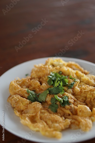 Angle view of Omelet top with coriander on wood table.(Thai style)