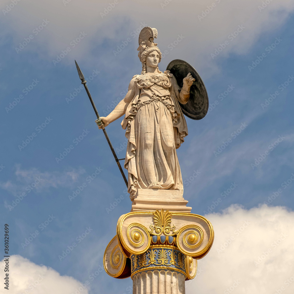 Athena the goddess of knowledge and wisdom marble statue on Ionic column and partly cloudy sky