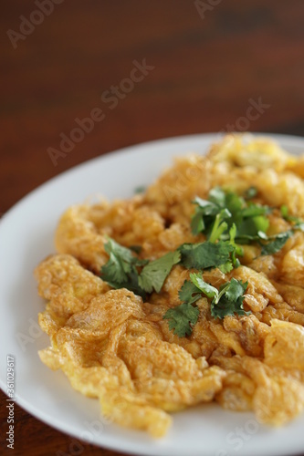 Angle view of Omelet top with coriander on wood table.(Thai style)