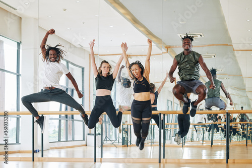 Multi-ethnic group of happy dancers jumping from excitement after productive training