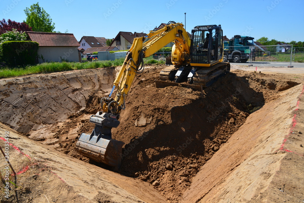 Εκτύπωση καμβά Bagger hebt auf einem Bauplatz im Neubaugebiet eine Baugrube aus