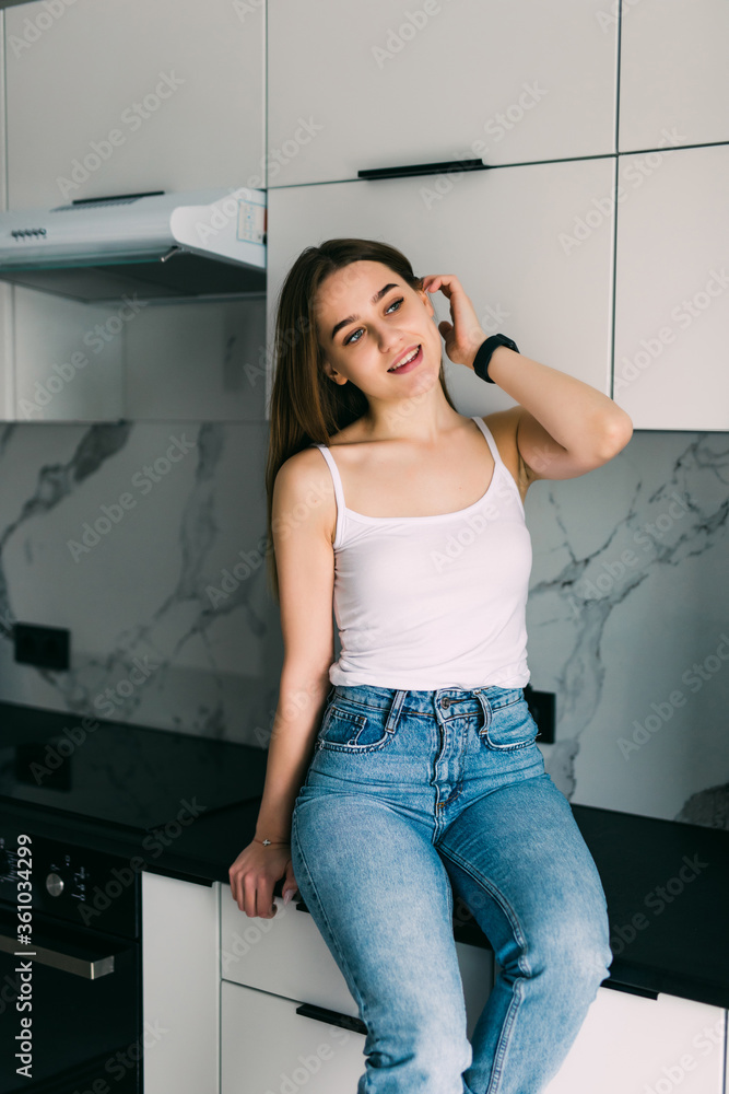 Young pretty woman sitting a table in the kitchen . Young pretty woman sitting a table in the kitchen .