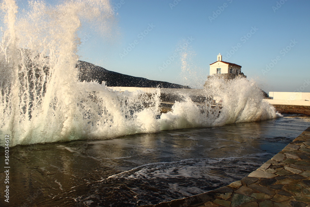 Waves at the small harbour in front of the Chapel of Panagia Thalassini at Andros, Greece 